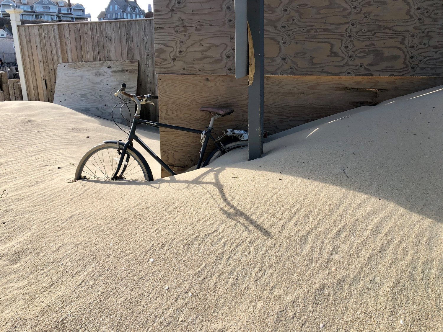 Sand covers a bicycle outside Galley Beach restaurant.