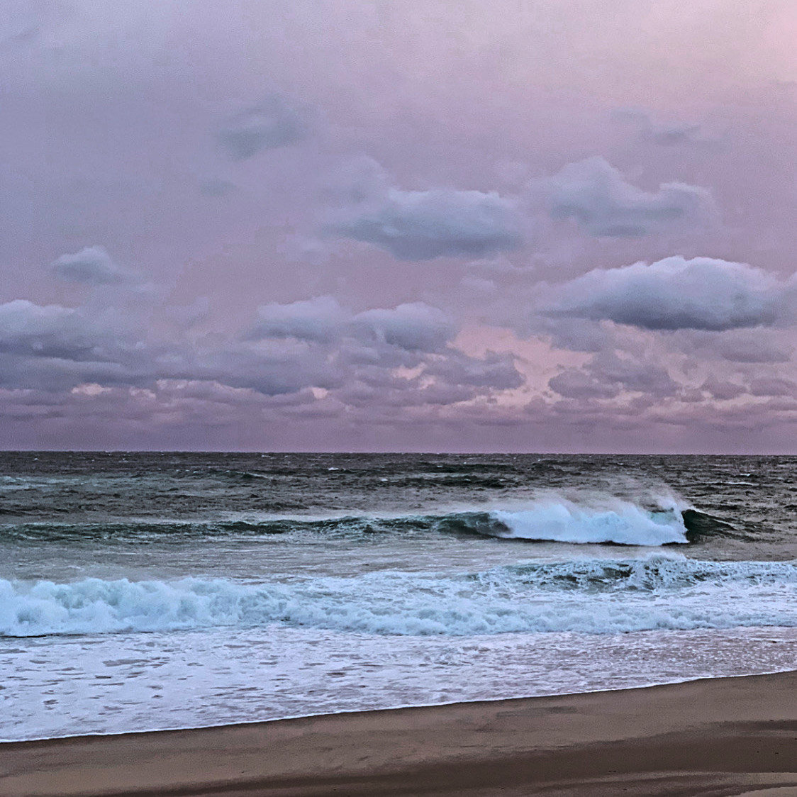 Breaking waves beneath a purple sky Feb. 18.