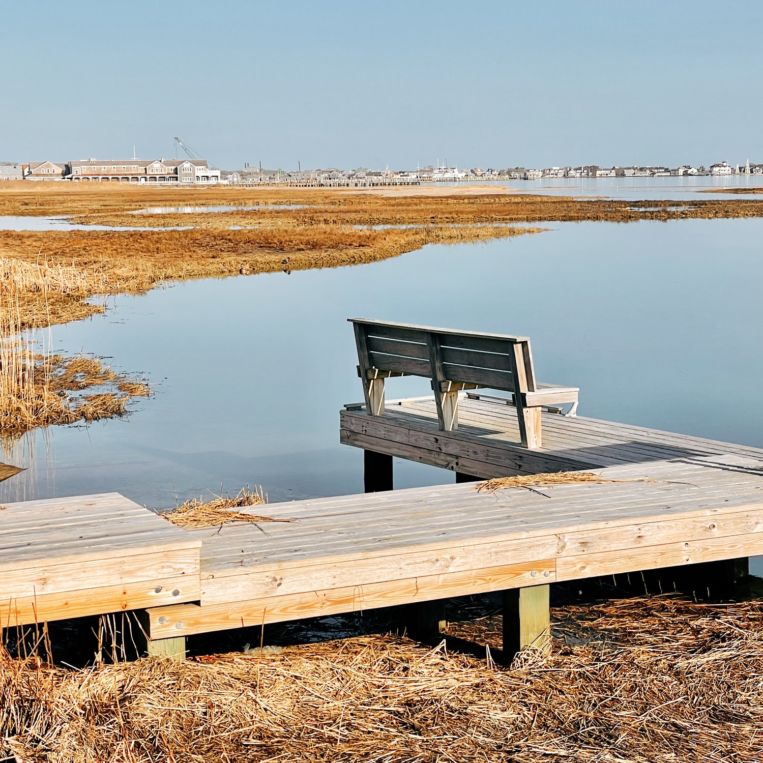An empty bench overlooking Nantucket Harbor awaits warmer weather.