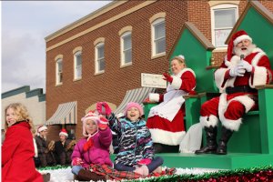 Children ride next to Santa and Mrs. Claus in a previous Greater Manassas Christmas Parade. (photo from the Greater Manassas Christamas Parade website.)
