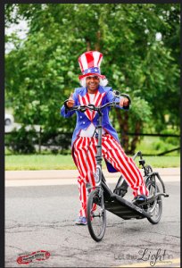 The Running Store employee dresses like Uncle Sam while driving an ElliptiGo. 