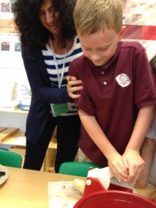 Student prepares potato to make French fries with the help of his teacher, Anita Ercole. 