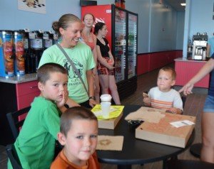 Mom, Angela, with her sons (counter-clockwise) Judah, Micah and Isaih, enjoy donuts on the first day of the shop's opening. 