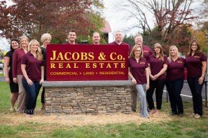 The team at Jacobs & Co. Real Estate stands outside their new office. 