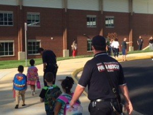 Firefighter escorts children into their new elementary school. 