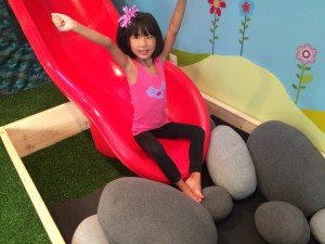 Lily plays on a slide in her basement, which was built for her when she was unable to play outside. 