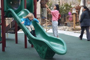 One girl goes down the slide during recess. 