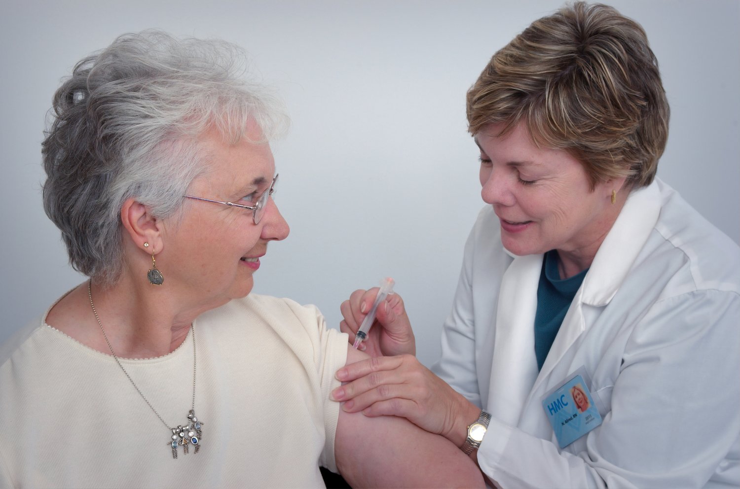 Health care worker provides a vaccination to a senior woman