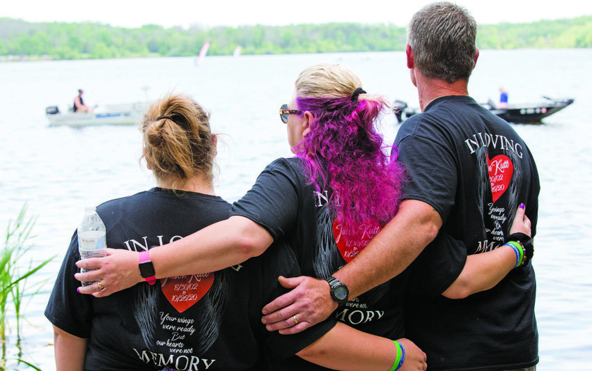 The family of Jason Kutt, an 18-year-old Sellersville resident who was fatally shot at Lake Nockamixon in October 2020, watch a parade of boats pass by the site of a memorial bench that was dedicated in his honor. The boats, as they passed by the shore, played one of Kutt’s favorite songs by the band Metallica. From left are Kutt’s sister, Brianna Hill; his mother, Dana Kutt; and his father, Ron Kutt.