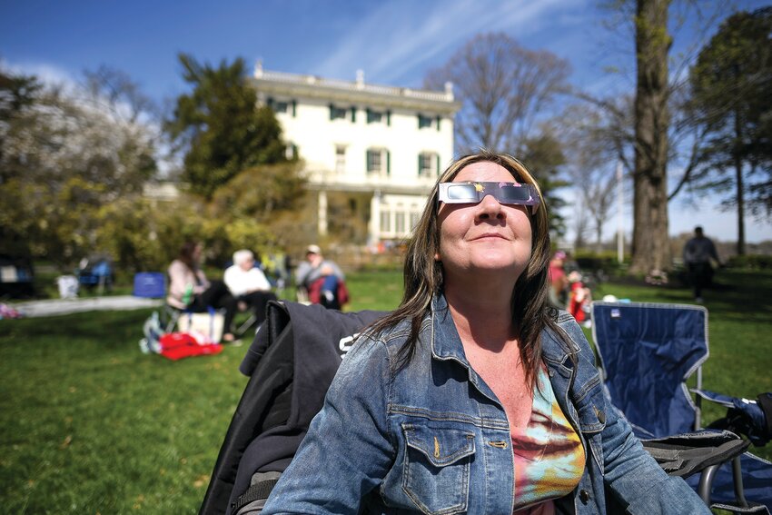 At Glen Foerd in Philadelphia, Lori Konrad gets a glimpse of the solar eclipse before clouds cover the skies.