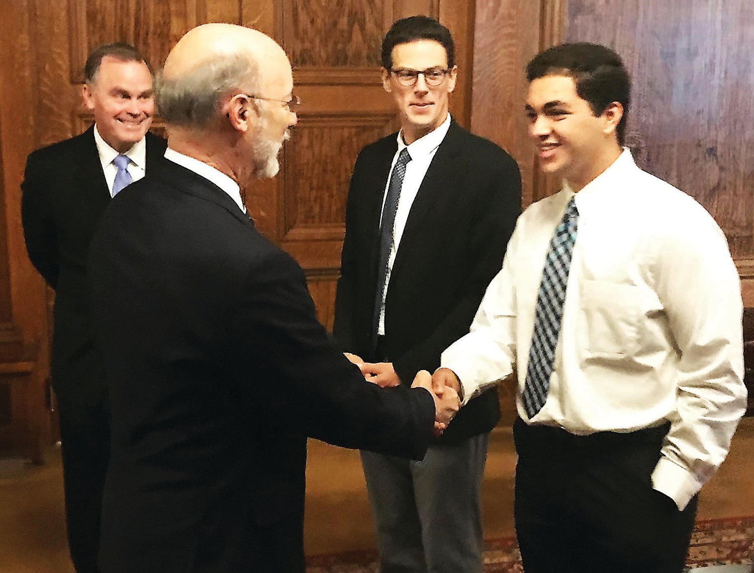 Gov. Tom Wolf shakes hands with Quakertown AP Government student Andrew Labeeb as Superintendent Dr. Bill Harner, left, and Trumbauersville Elementary School Principal Adam Schmucker look on.
