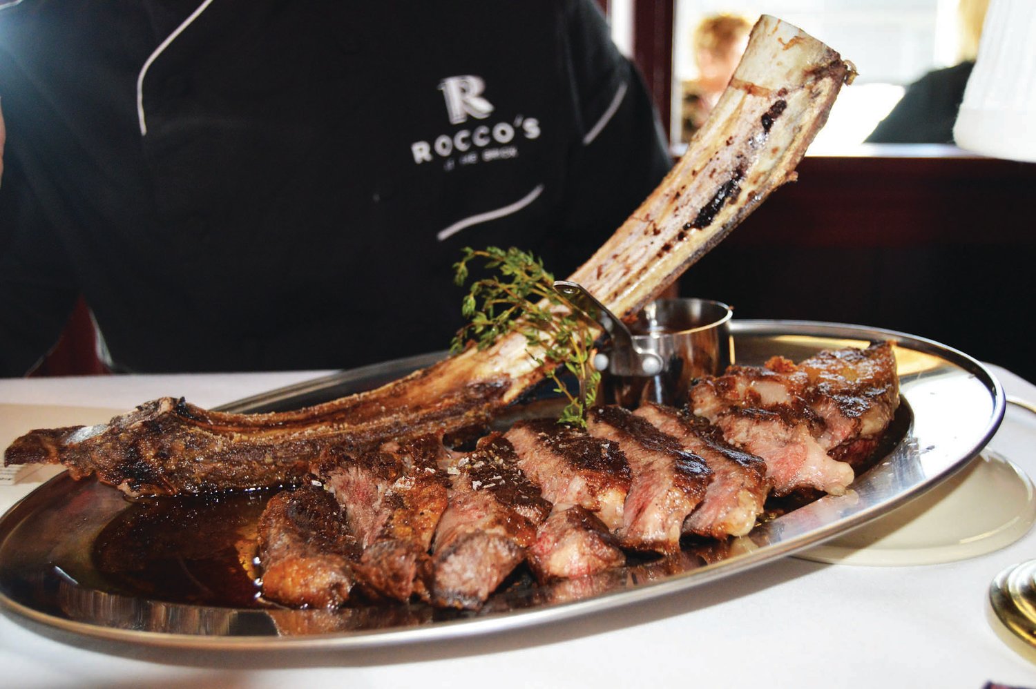 Giving the gift of a dining out experience is easy with a restaurant gift card. Here is a steak lover’s dream: a  tomahawk steak at Rocco’s at the Brick in Newtown. Photo by Susan S. Yeske