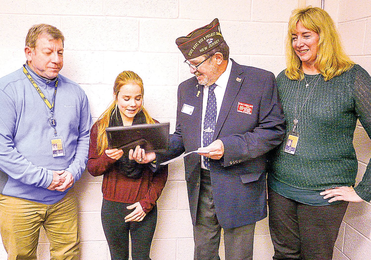 Gerald Cadwallader of the VFW presents Del Val High School sophomore Clare Erwin with a plaque and a check for winning the Hunterdon County Voice of Democracy competition. They are flanked by teacher Jim Kluska and Principal Adrienne Olcott.