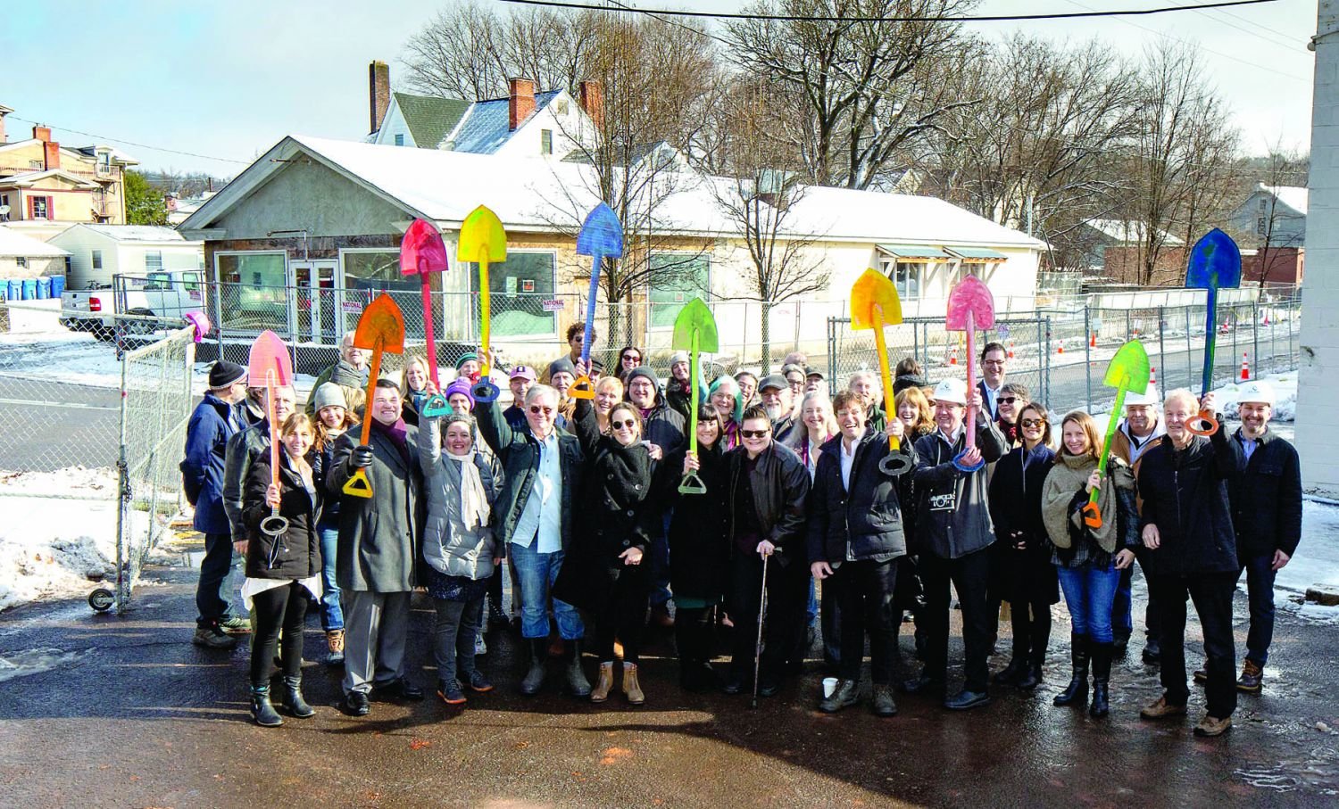 Holding painted cardboard shovels aloft, officials are joined by ArtYard staff and well wishers at the groundbreaking for a new arts center Monday.  Photograph by Paul Warchol and courtesy of ArtYard.