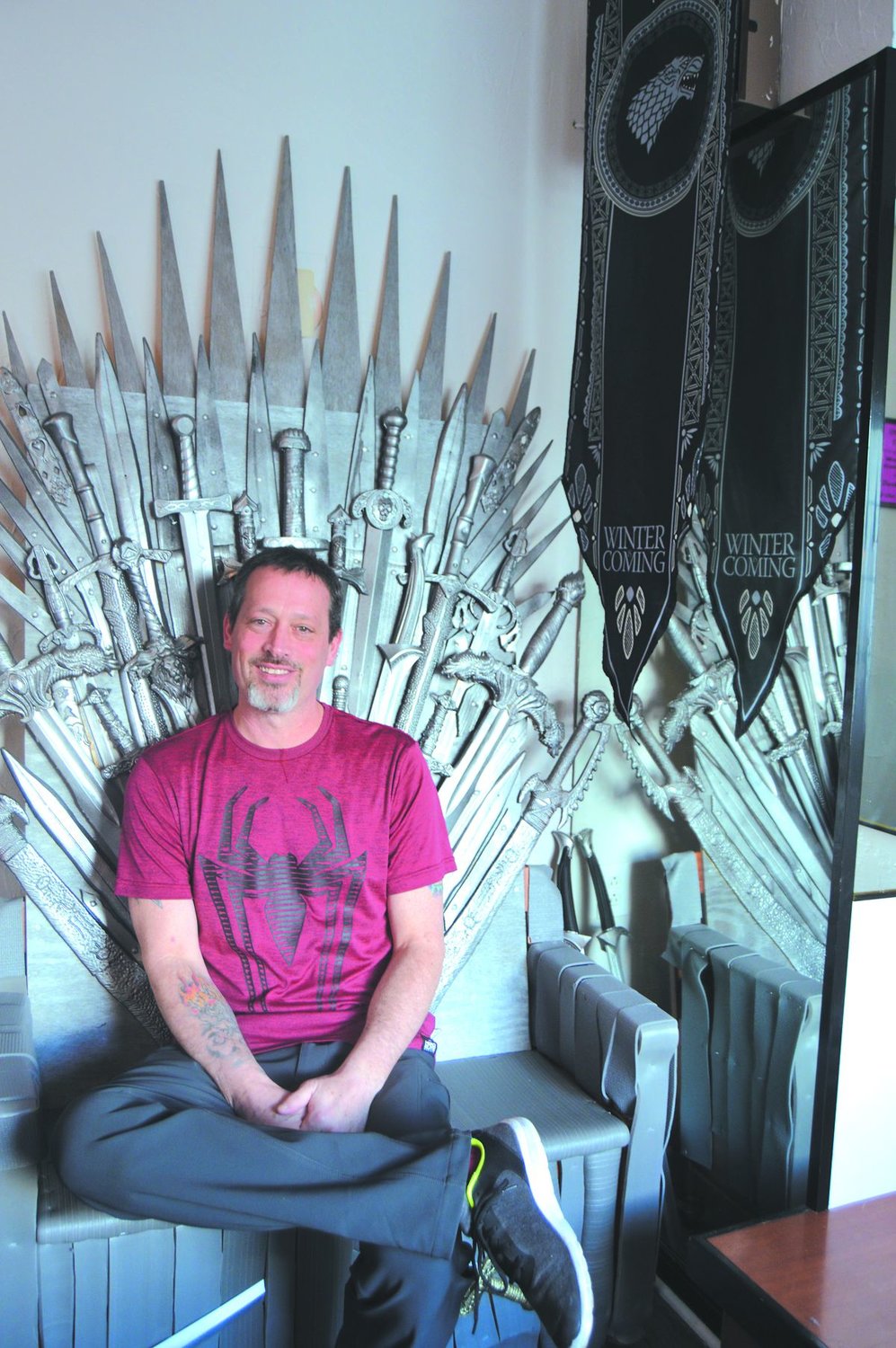 Brent Tutwiler sits in his replica of the Game of Thrones throne that he built for his pop culture-themed tavern, Pop Inn in Chalfont. Photograph by Susan Yeske.