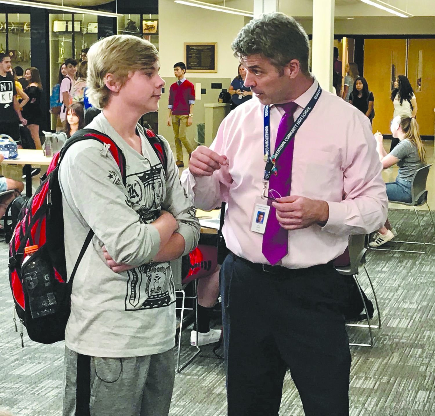 Dr. David Finnerty speaks to a student in the high school’s cyber commons area.