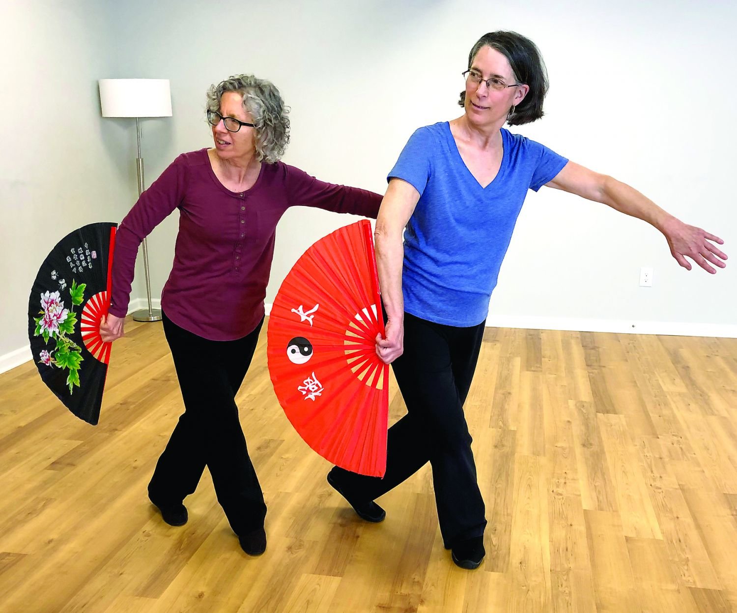 Diane Alex, left, and Kate Kane practice a Tai Chi fan form, which will be demonstrated at Koru Real Wellness April 27.