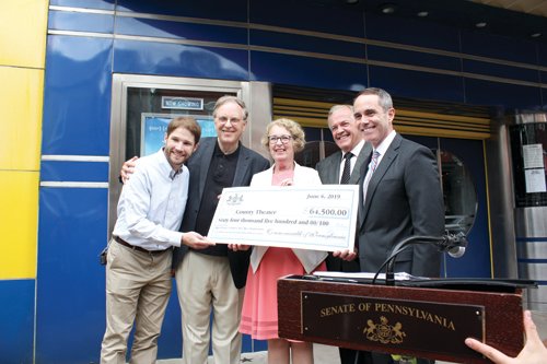 Chris Collier, executive director, County Theater; John Toner, founding director, County Theater; state Rep. Wendy Ullman; Doylestown Mayor Ron Strouse and state Sen. Steve Santarsiero stand outside the theater with a ceremonial check representing the $64,500 grant from the Pennsylvania Historical and Museum Commission.