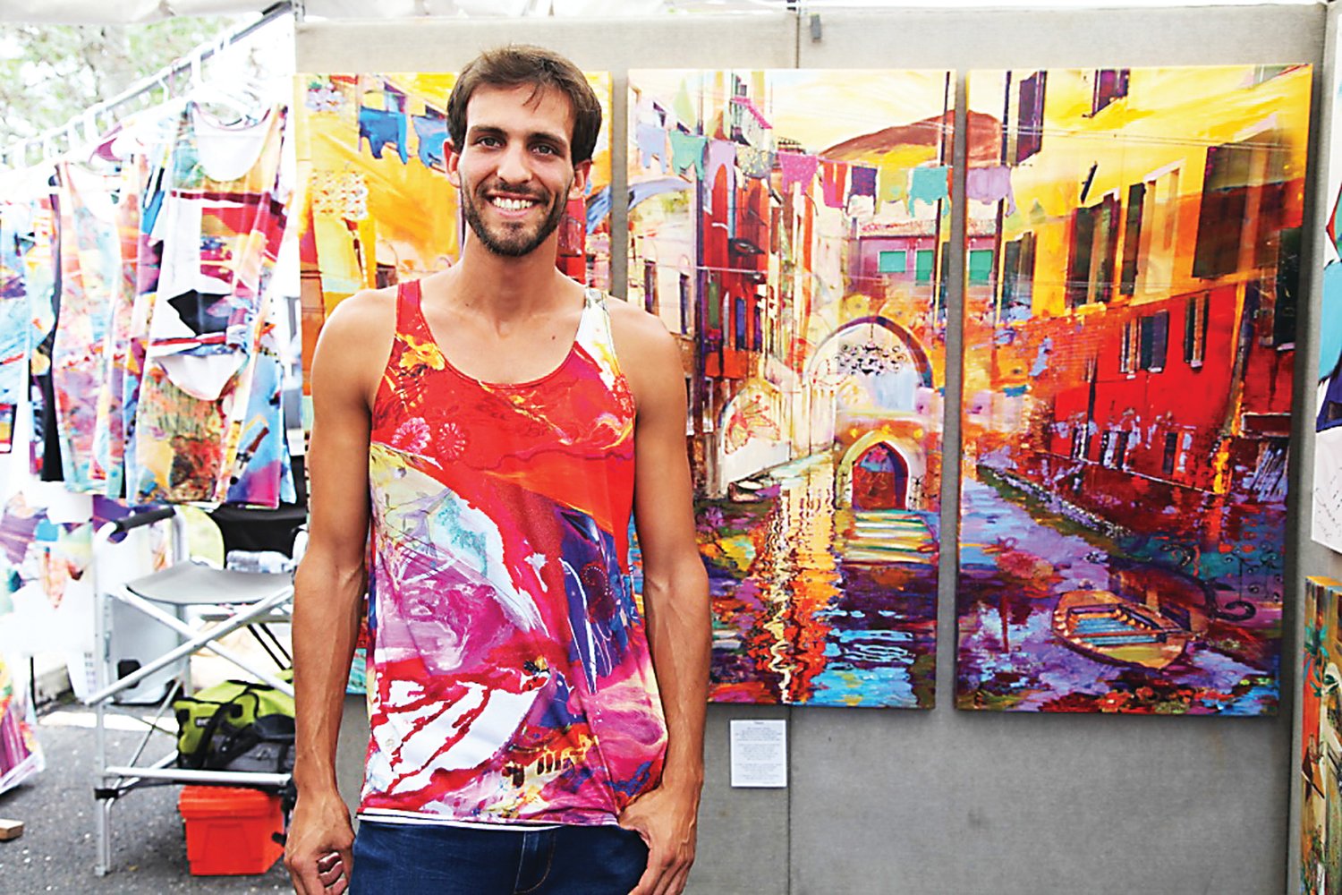 A representative for artist Smadar A. Livne, with one of the painter’s canvas works and tank tops bearing her art. Photograph by Chris Ruvo.