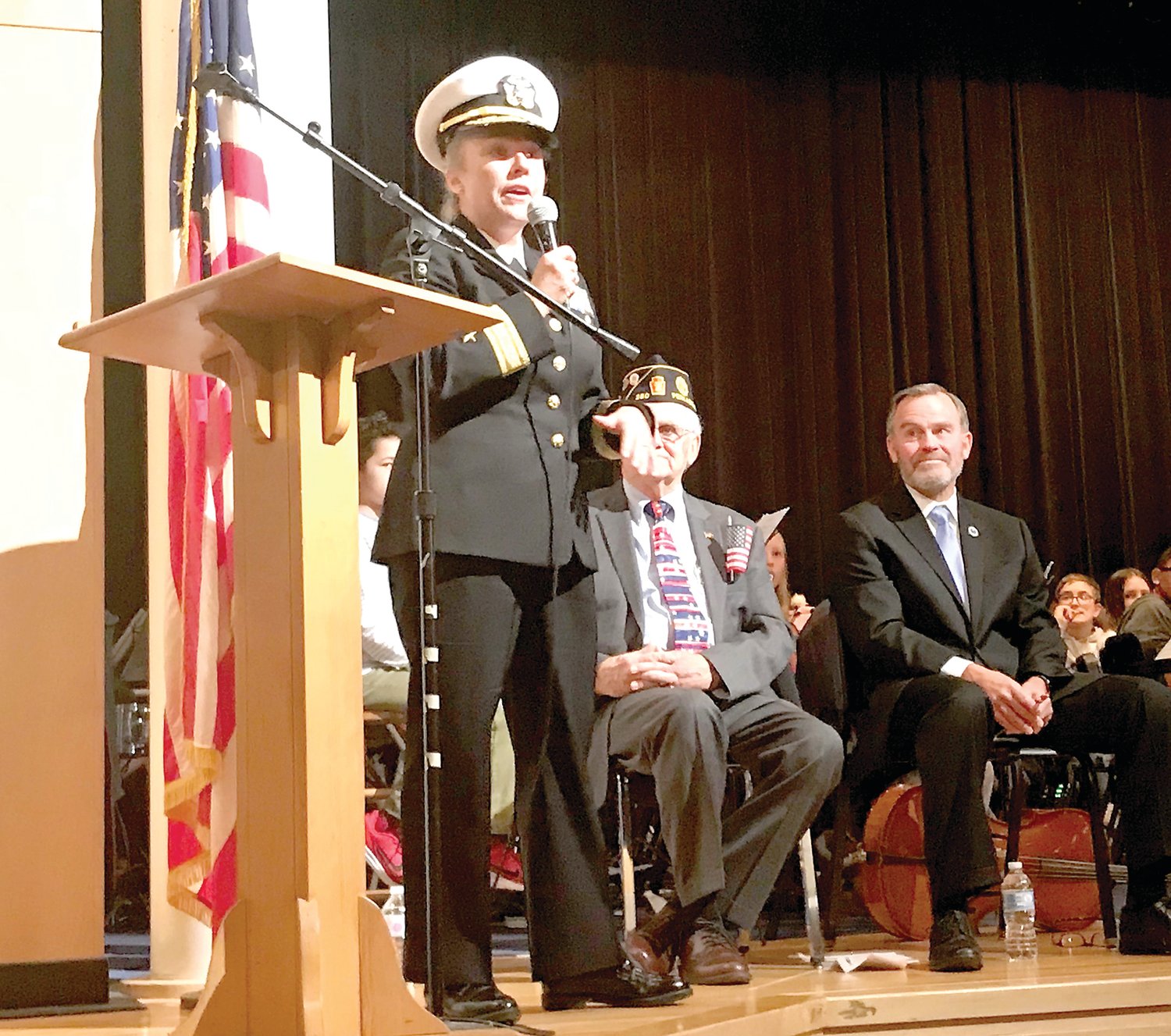 Navy Rear Adm. Linda Wackerman speaks to the crowd in the Strayer Middle School auditorium. Seated are Quakertown Superintendent Dr. Bill Harner, right, and former state Rep. Paul Clymer.