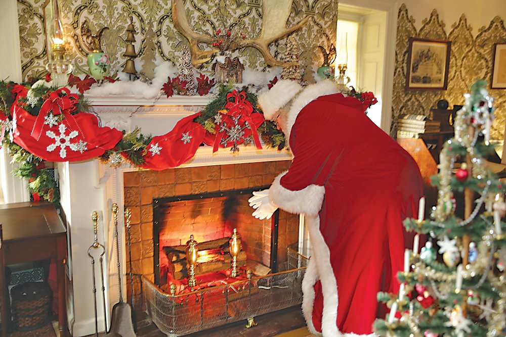 Santa warms his hands by the fire at Pennypacker Mills.