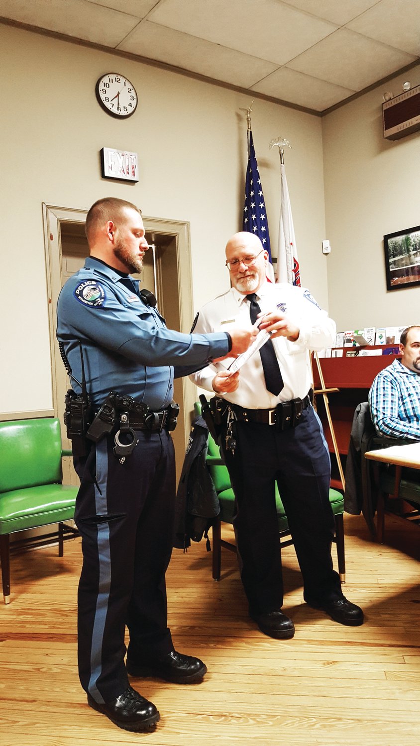Bedminster Patrolman Nick Virnelson received the township’s Life Saving Award from Chief Mark Ofner at the Nov. 13 board of supervisors meeting. Ofner told how Virnelson saved the life of a resident heroin overdose victim, by first reviving him, and then having to do it again, while coping with a violent response from the victim. Photograph by Cliff Lebowitz.
