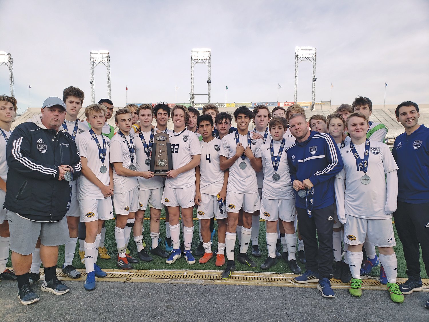 New Hope-Solebury boys soccer players stand with the PIAA Class 2A runner-up trophy. Photograph by Karen Sangillo.