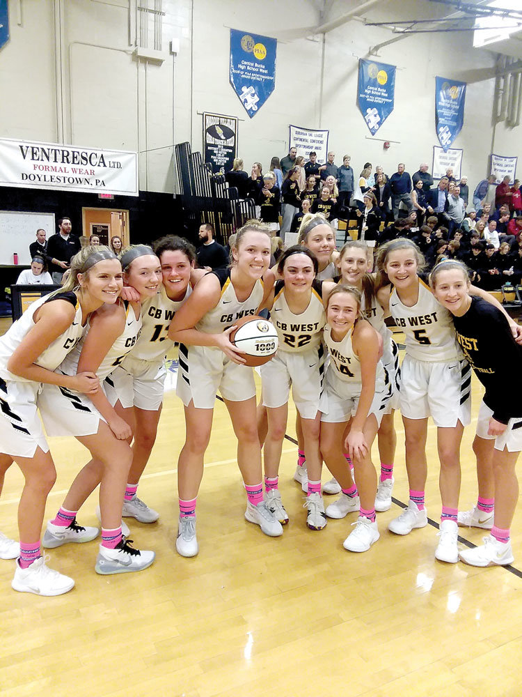 CB West’s Maddie Burke, surrounded by her teammates, celebrates scoring her 1,000th point following last Friday’s 56-37 defeat of CB East. Photograph by Don Leypoldt.
