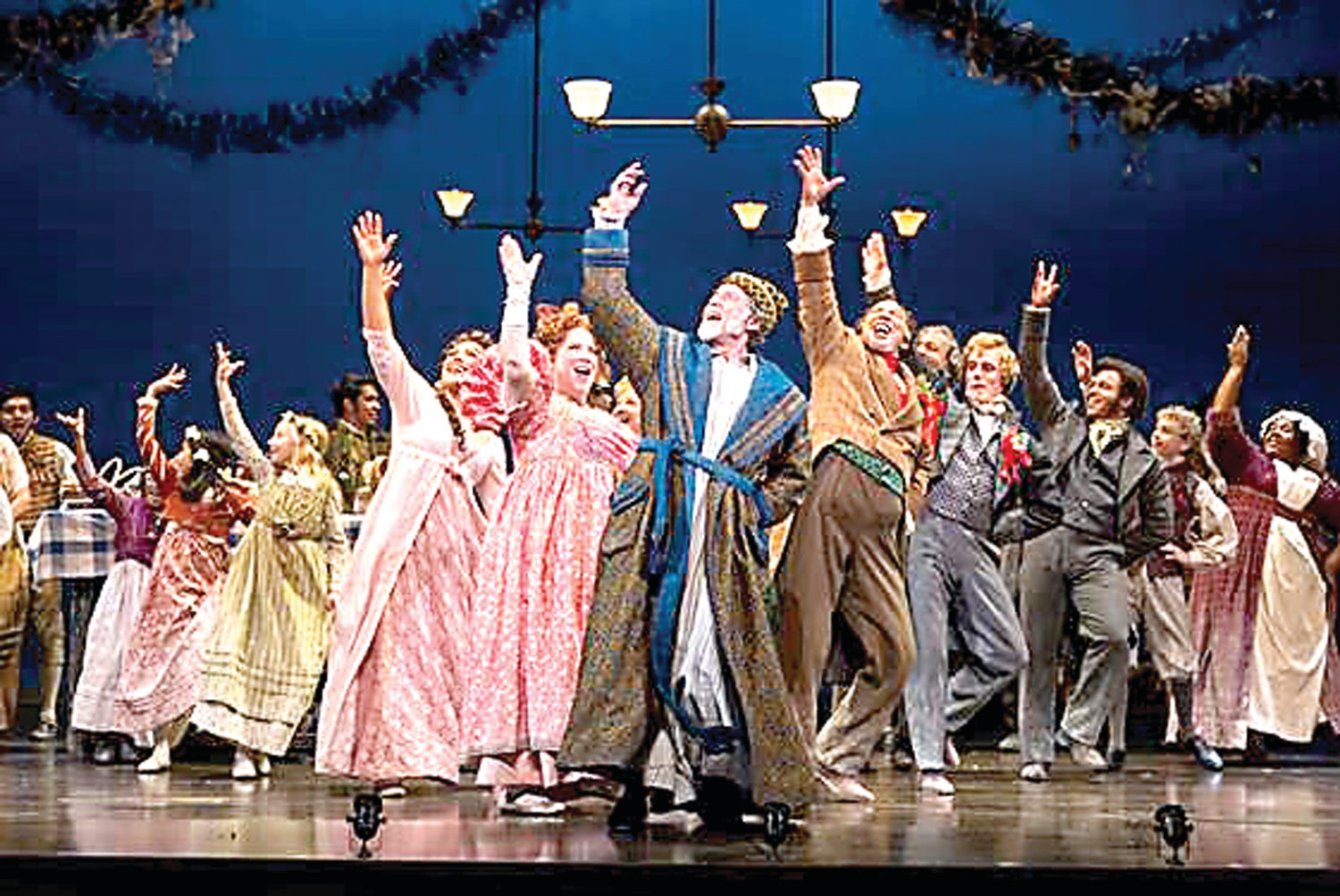 Greg Wood, center, and members of the 2017 “A Christmas Carol” ensemble perform on stage. The 2019 show runs through Dec. 29. Photograph by T. Charles Erickson.