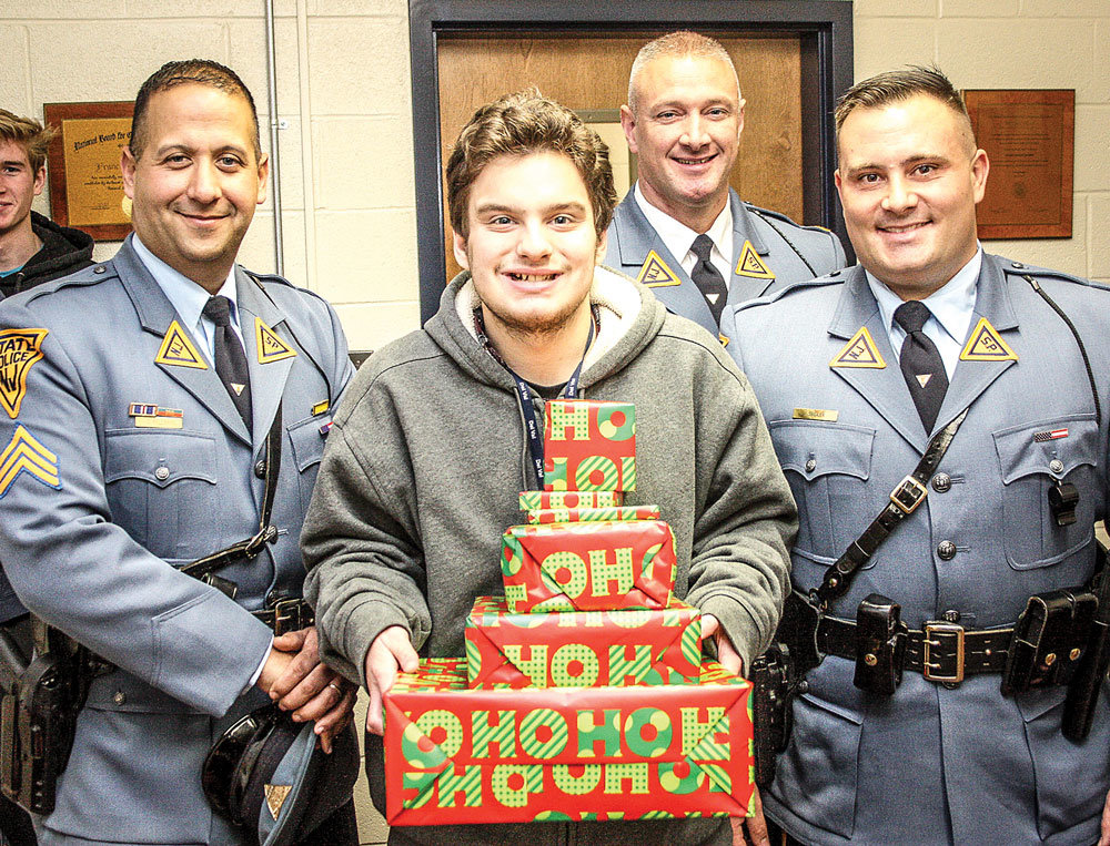 Theo Baransky of Milford, N.J.,  is the recipient of this year’s shower of gifts from the troopers of the Kingwood station. With him are, from left, Sgt. Scott Feldman, Lt. Sean O’Conner and Trooper Joe Seidler.