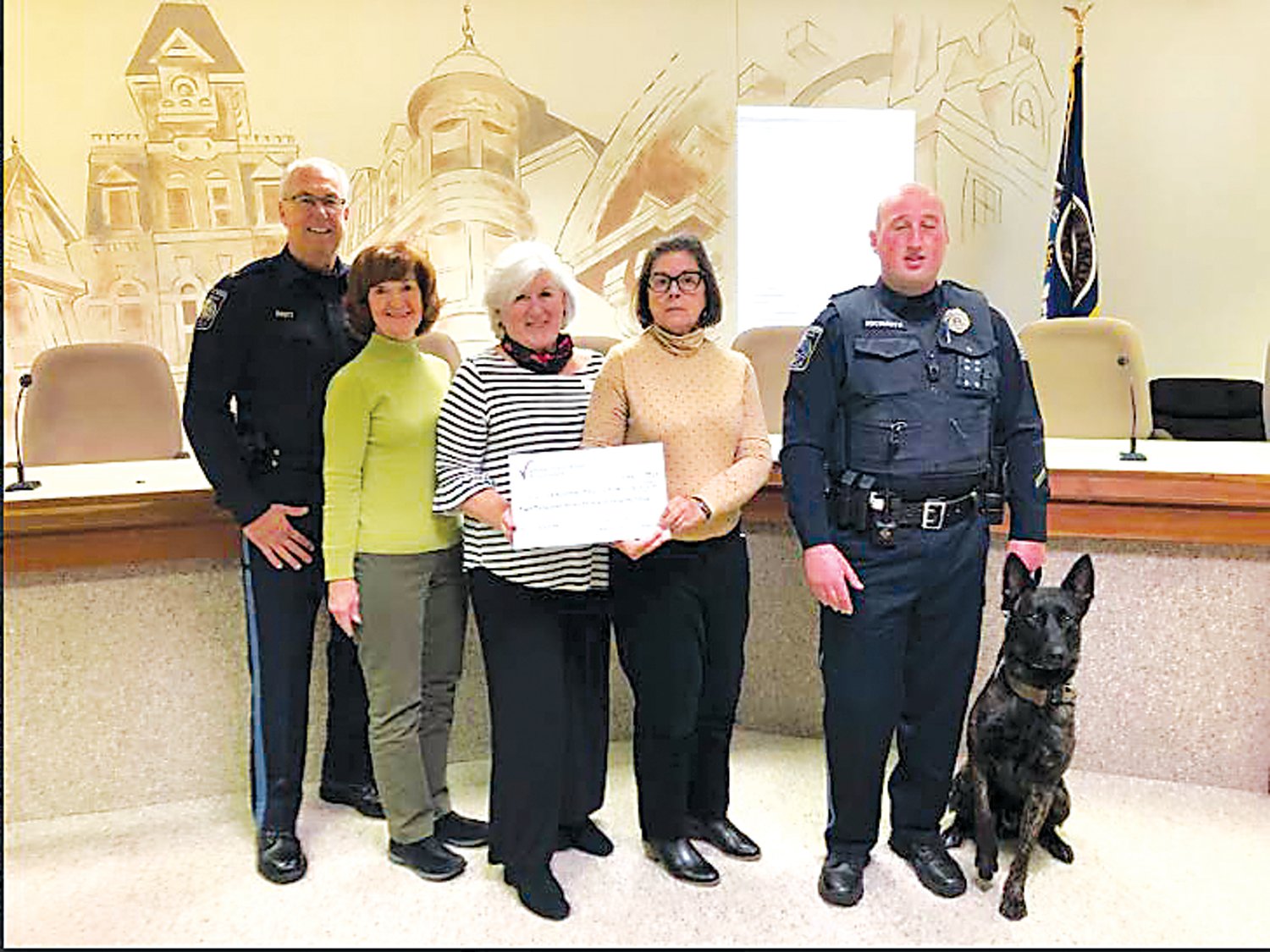 From left are: Chief Karl Knott, Mary Ellen Stanton, Marilyn Mele, Barbara Ann Price, Officer Andrew Hochmuth and, star of the event, Baron.