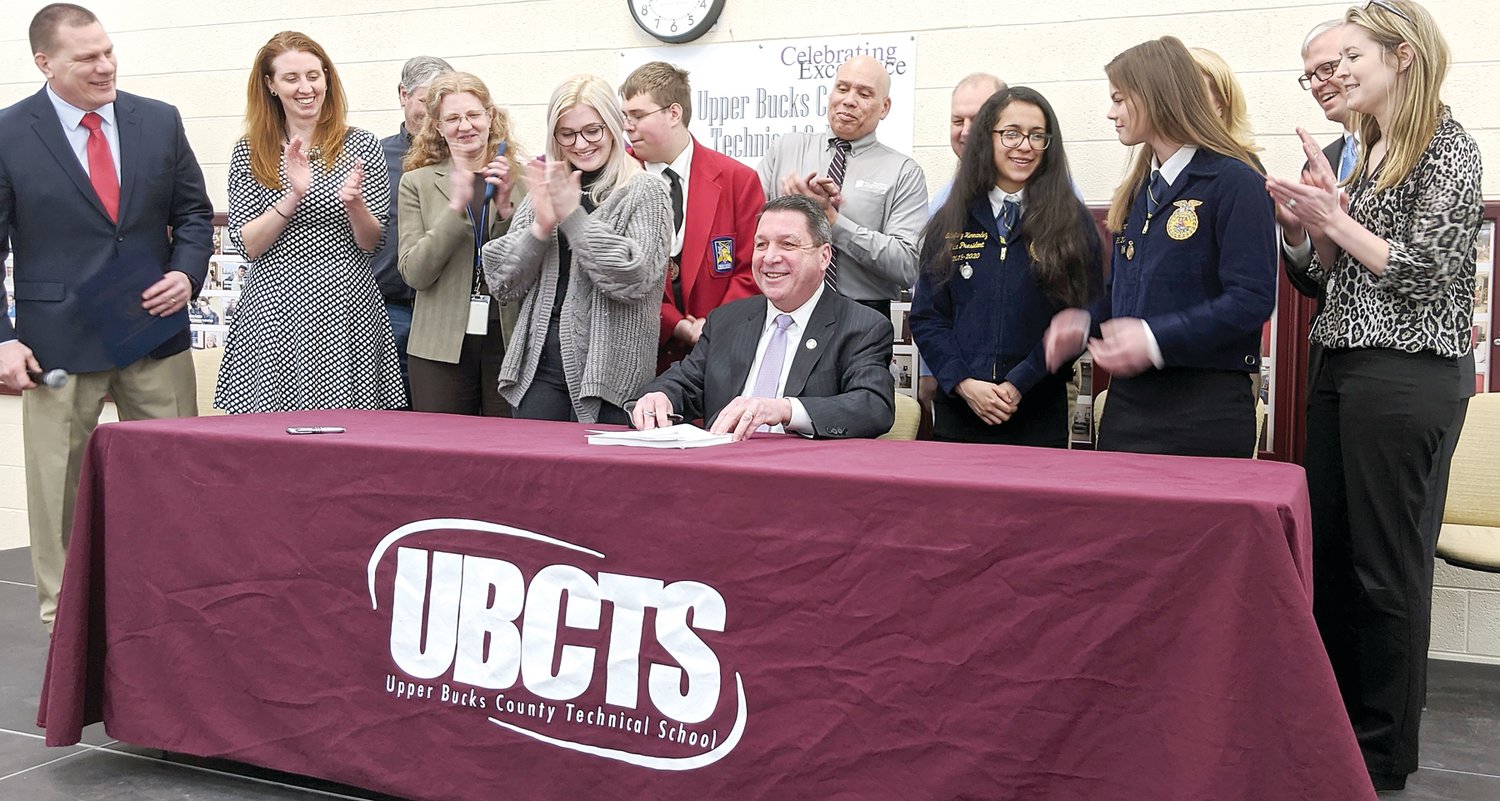 State Rep. Craig Staats (seated) was at the Upper Bucks County Technical School on Feb. 21 for the ceremonial signing of Act 76, the first major update to technical education in 30 years. Photograph by Joe Ferry.