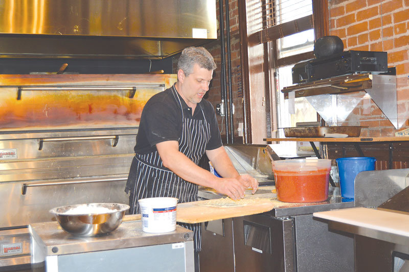 Steven Calozzi makes a pizza at Russo’s pizza, located in the former Town Hall in New Hope. Photograph by Susan S. Yeske.