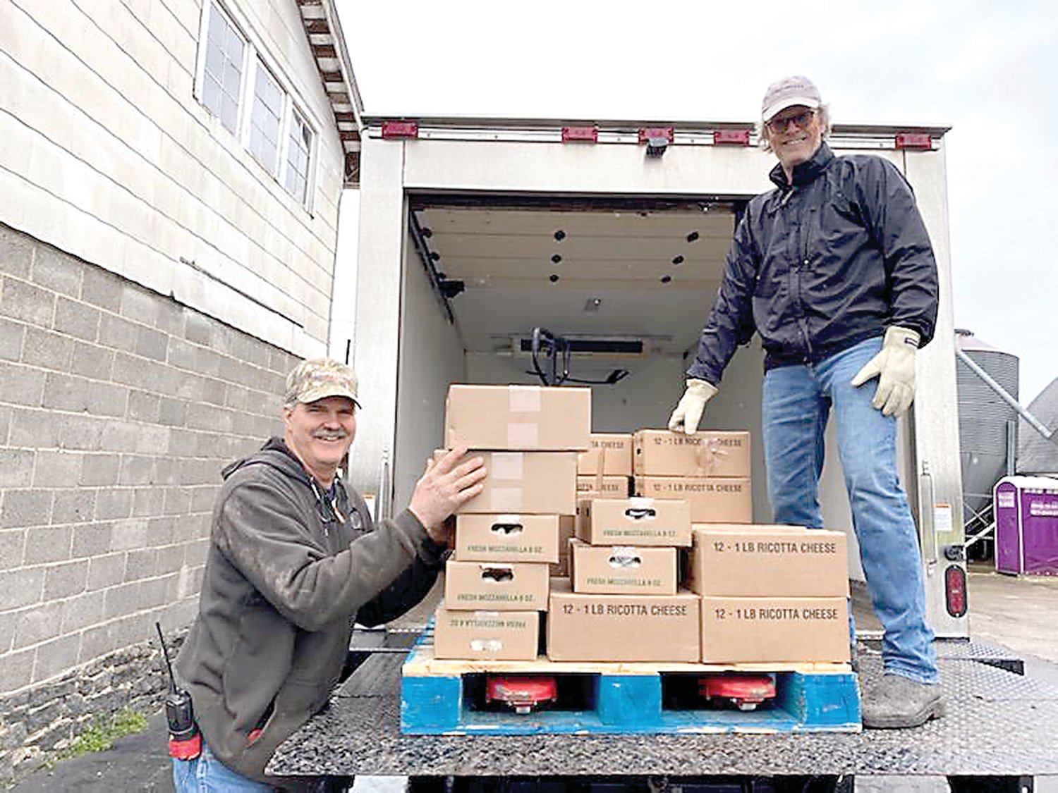 Rob Fulper, left, owner of Fulper Family Farmstead, helps Jay Quilty of Rolling Harvest Food Rescue load dairy products into the truck.