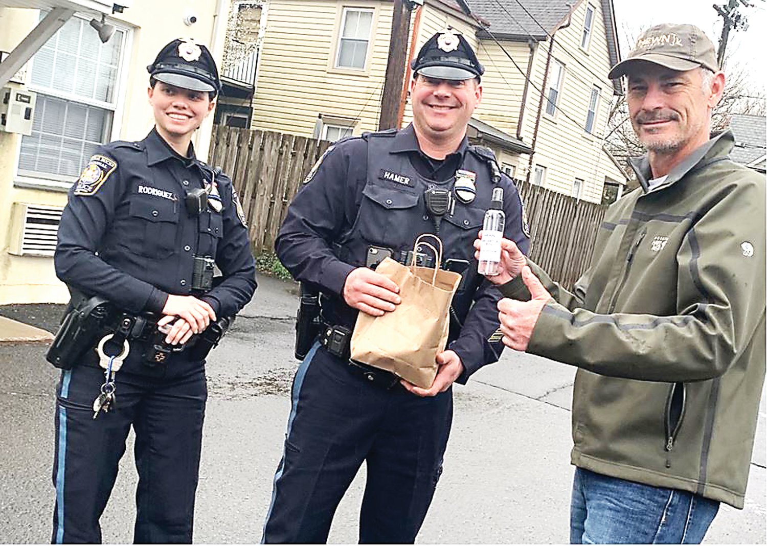 Officers Rodriguez and Hammer from the Central Bucks Regional Police Department pick up hand sanitizer from Sean Tracy of Hewn Spirits in Pipersville.