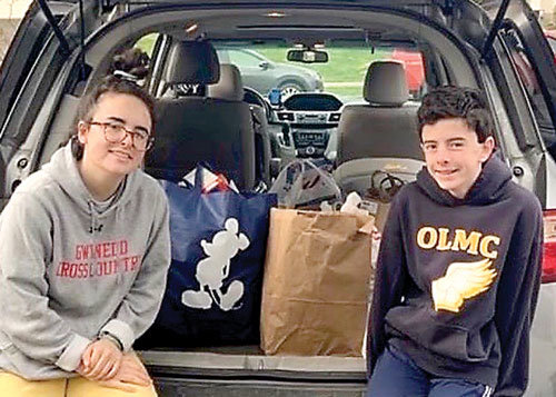 Students collect donations of food, one of several community service projects conducted by members of the Our Lady of Mount Carmel School community.
