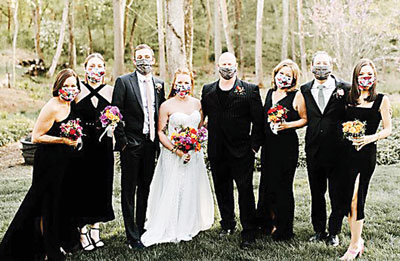 The wedding party poses with masks. From left are Kendra Lelie, Hannah Lelie, Jaxon Vallely, Kaelyn Lelie Vallely, Gene Lelie, Sandra Vallely, Eugene Vallely, Eden Vallely.