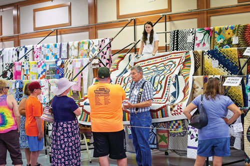 Visitors to a prior Kutztown Folk Festival tour the Quilt Barn.