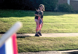 Harmony Brehm, 7, held out longest in the family flag delivery. She walked 5 miles placing flags on local lawns. (William Brehm)