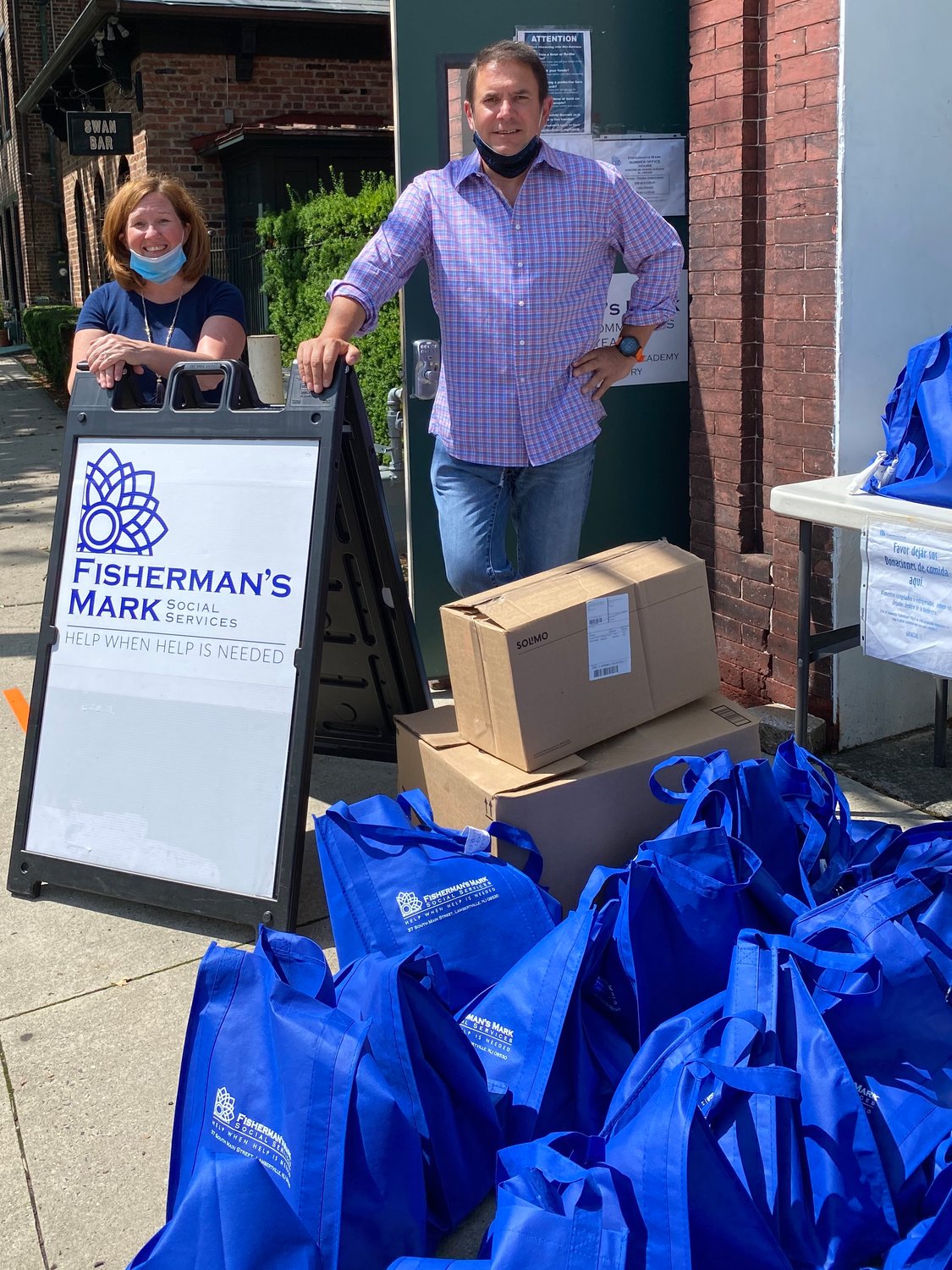 Jennifer Williford, executive director of Fisherman’s Mark in Lambertville, N.J., and Glenn M. Davis of Benchmark Lending stand in front of Fisherman’s Mark with the personal hygiene kits donated by Benchmark Lending. Throughout the pandemic, the Benchmark team has been reaching out to local nonprofits to provide the most needed items on their “wish list.”