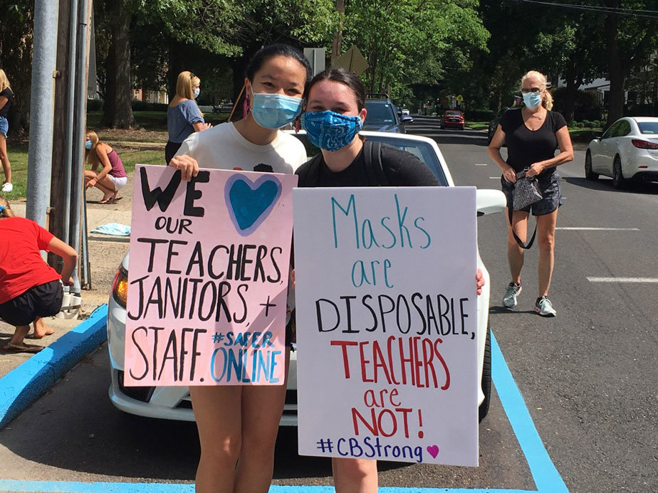 Amy Liu, left, and Rachel Leopold, hold signs at Saturday’s rally supporting Central Bucks teachers and staff in Doylestown. (Freda R. Savana)