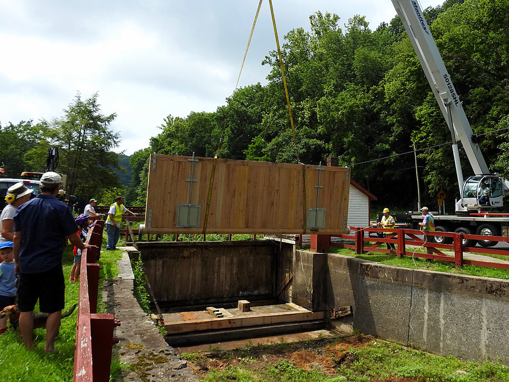 Spectators watch the installation of a new drop gate at Groundhog Lock on the Delaware Canal on July 23. Recent repairs will allow water from the Lehigh River to flow from Easton to New Hope. (Carole Mebus)
