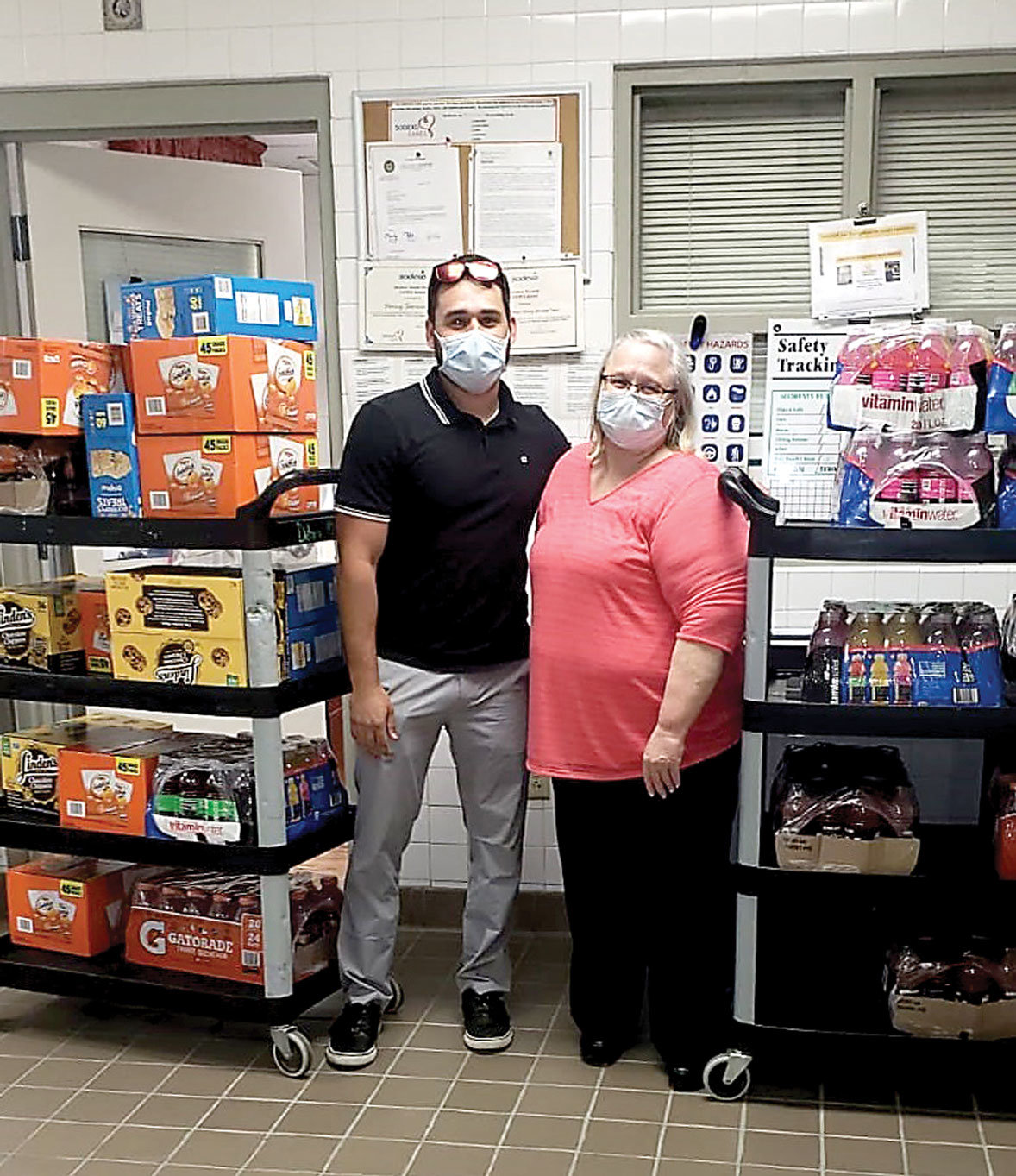 Greater BucksMont Chamber of Commerce Y2Y member Roman Chiokadze, left, and Judy Breinich, assistant director, dining services, Neshaminy Manor, right, with the donation of snacks and drinks for the staff at Neshaminy Manor.