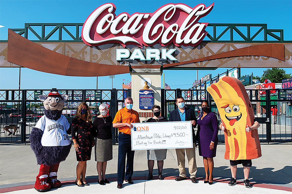 From left are: FeRROUS the mascot, Lori Knerr, QNB Bank vice president/branch manager; Sharon Michael, QNB Bank senior vice president, commercial lender; Brian Schaffer, QNB Bank senior vice president/CMO; Renee Haines, Allentown Public Library director; Kurt Landes, IronPigs president/general manager; Phoebe Harris, Allentown Public Library board member; and Chris P. Bacon.
