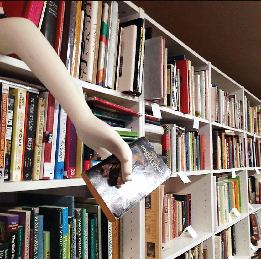 An arm reaching for books is a whimsical decoration at Inklings Bookshop.