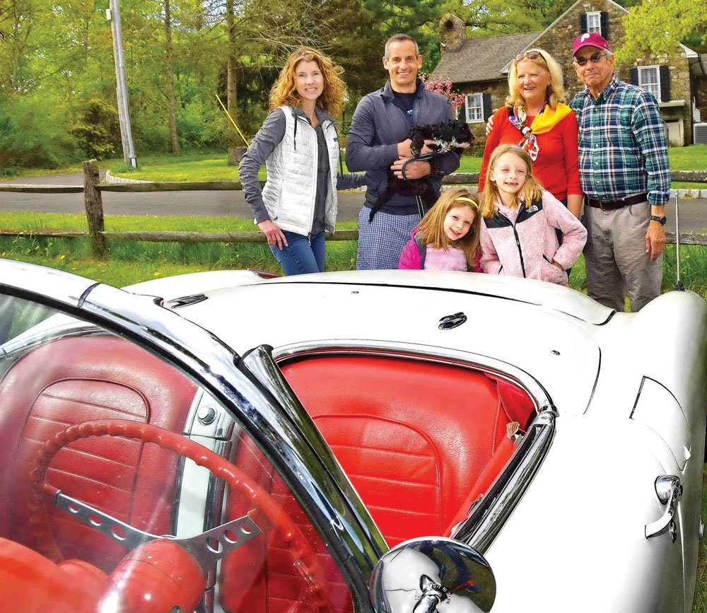 The Falconio family admires a Chevy Corvette.