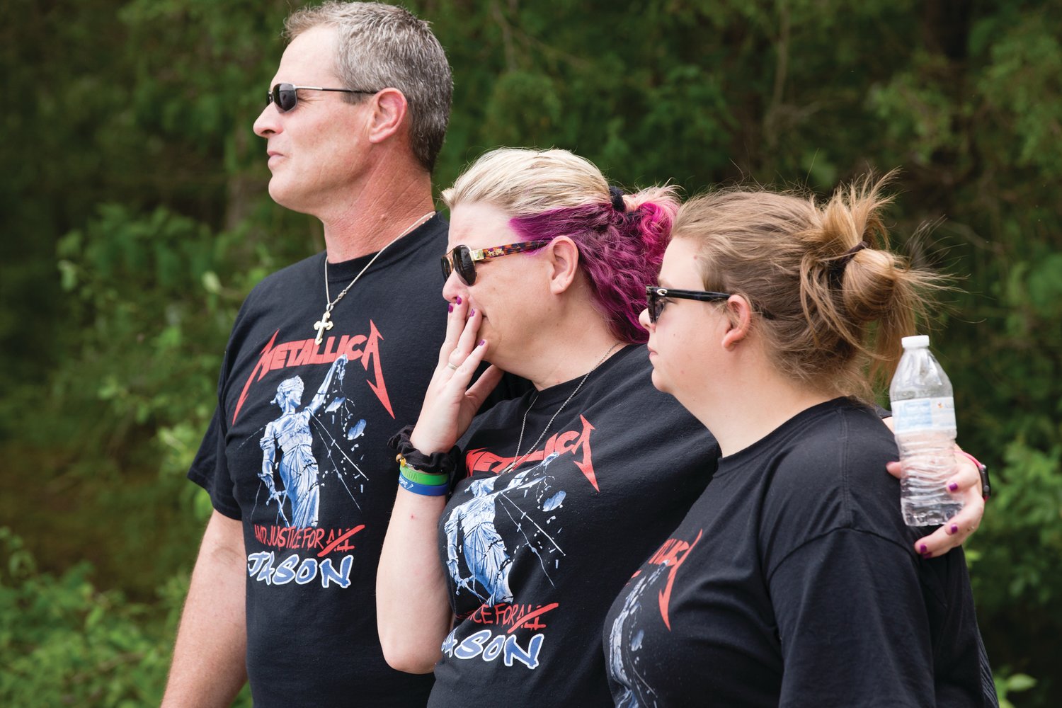 Ron Kutt, Dana Kutt and Brianna Hill, the parents and sibling of Jason Kutt, watch as a boat parade passes by a memorial bench that was dedicated in memory of the 18-year-old.