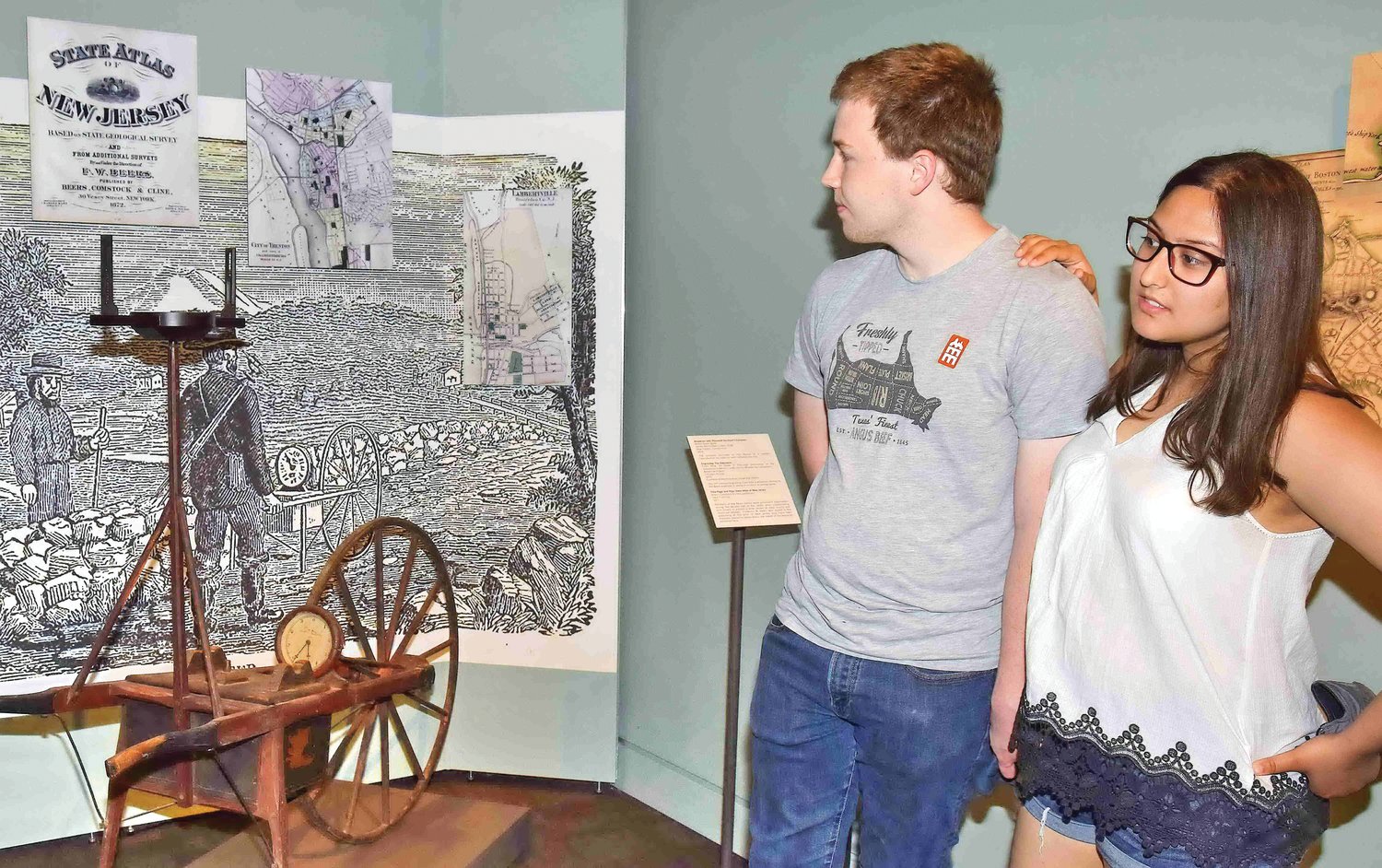 Luke Mueller-Odem and Olivia Dossa view an early New Jersey map and measuring device.
