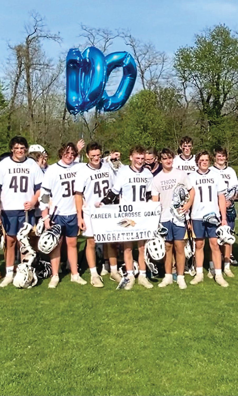 New Hope-Solebury boys lacrosse players join their teammate, Kyle McLaughlin, in celebrating his 100th goal. He finished his high school career with 126 goals and 93 assists for 220 points.