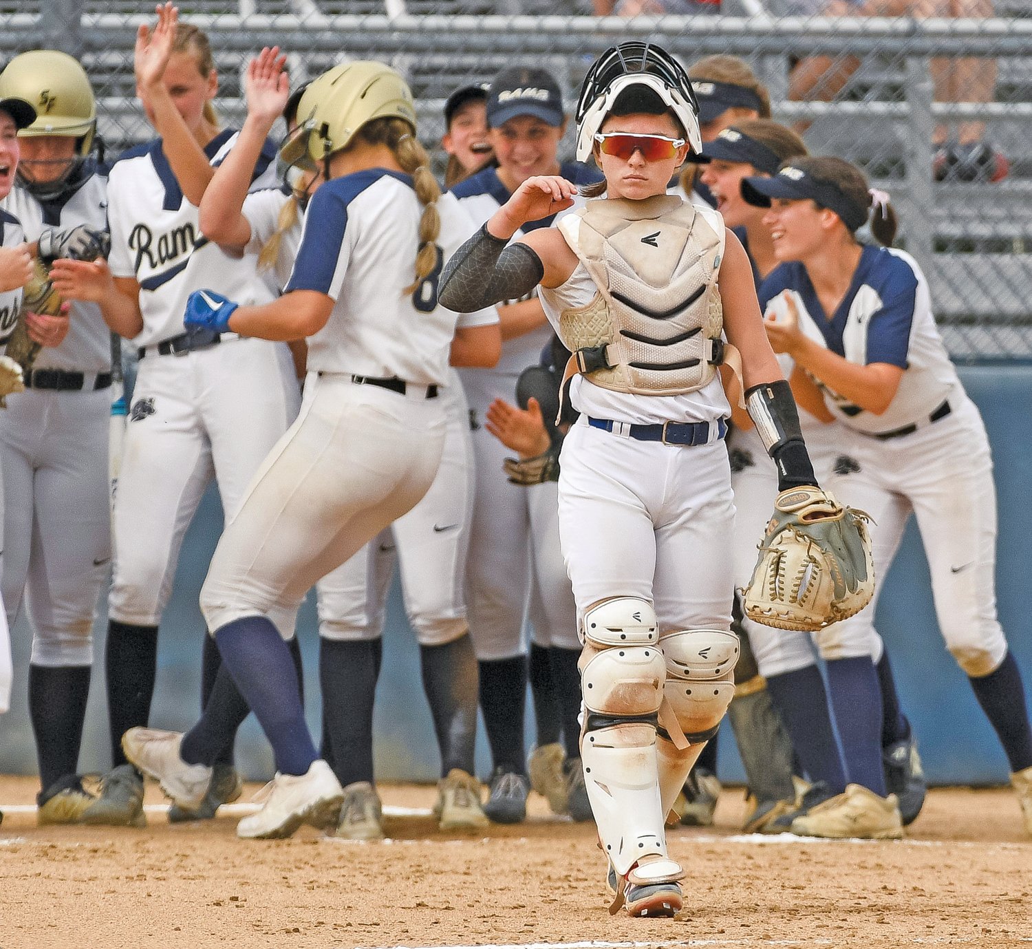 Quakertown catcher LauraRose Morelock walks to the mound as Spring-Ford’s Bri Peck crosses home plate after her third-inning home run, which put the Rams ahead 2-0.